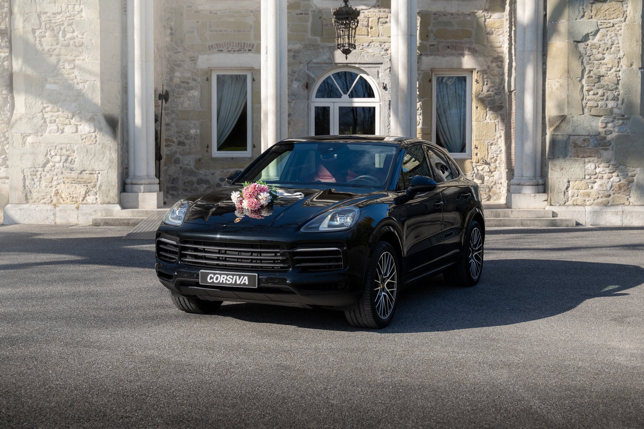 Porsche Cayenne Coupé décoré pour un mariage devant une bâtisse en pierre