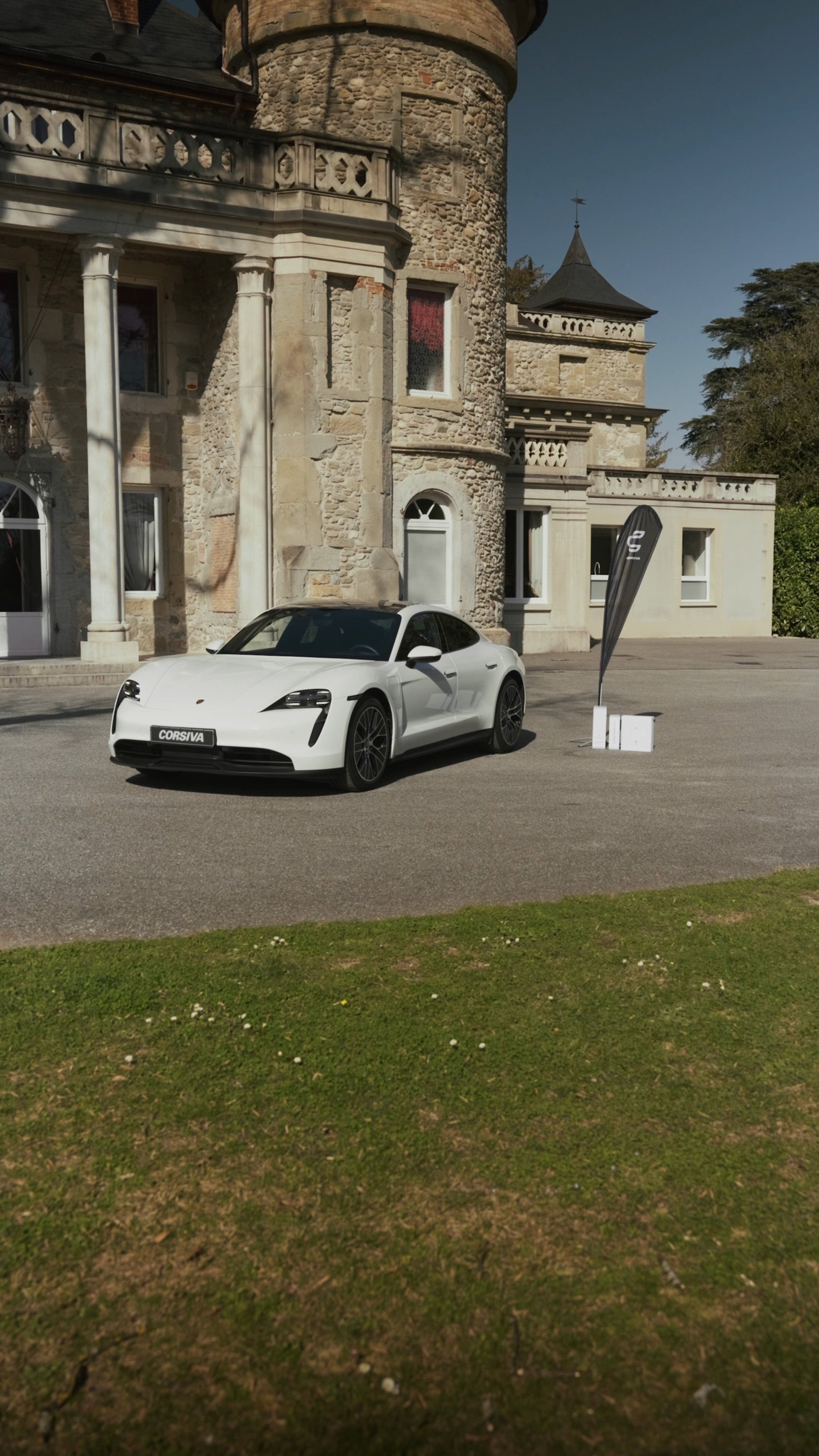 Porsche Taycan blanche devant le château de Servolex