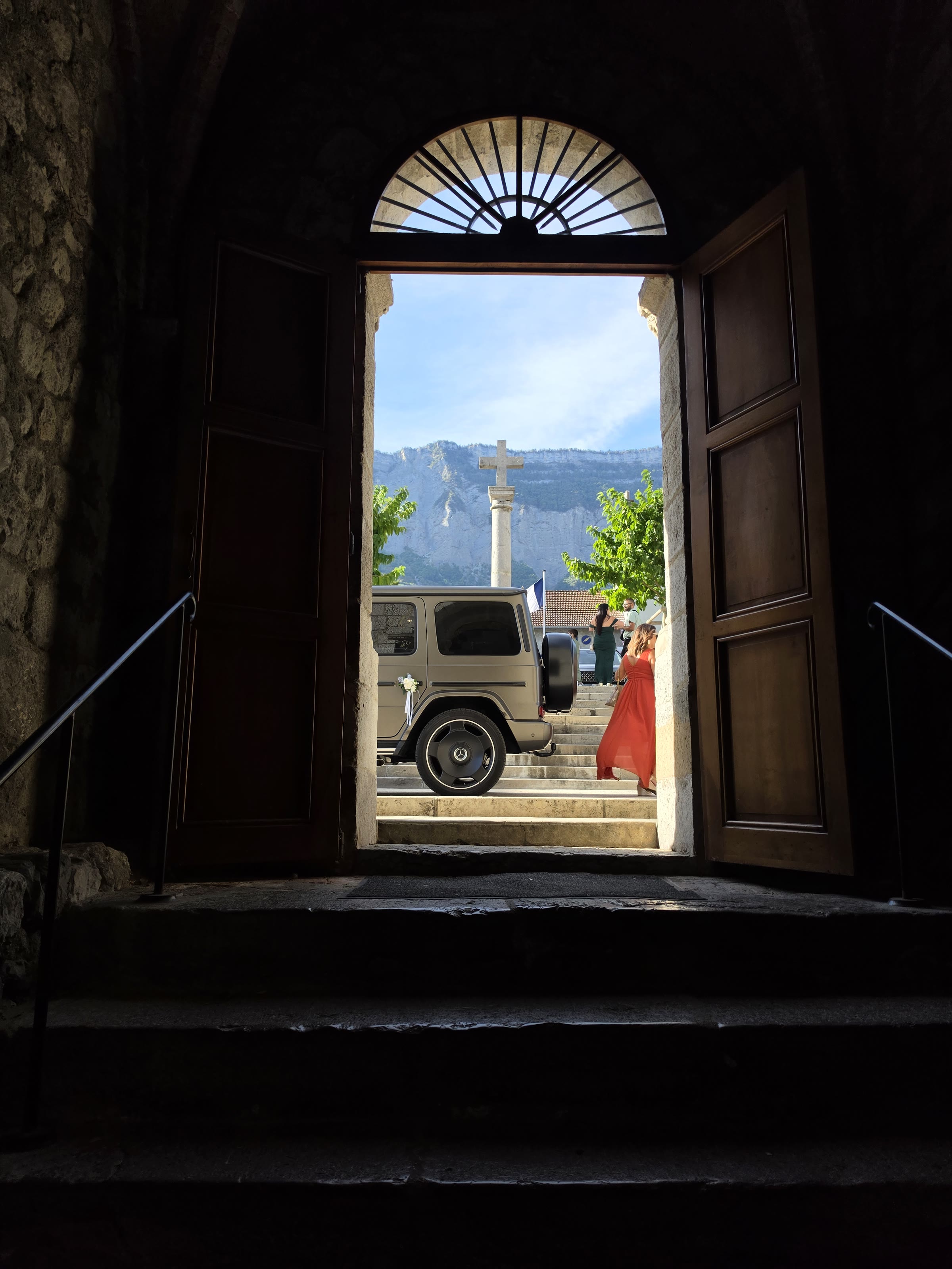 Mercedes Classe G 63 AMG 2025 vu depuis le porche de l’église, montagnes en arrière-plan